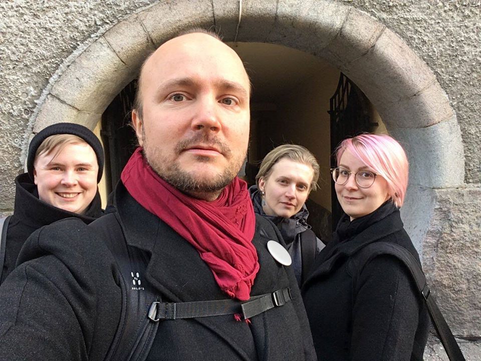 A selfie of four people posing in front of a gateway.